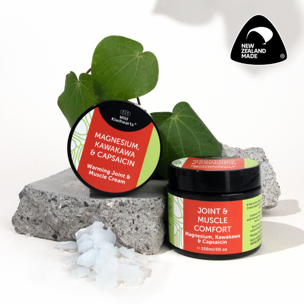 Two jars of Wild Kiwihearts Magnesium, Kawakawa & Capsaicin cream with green leaves and a rock on a white background, featuring New Zealand Made logo.