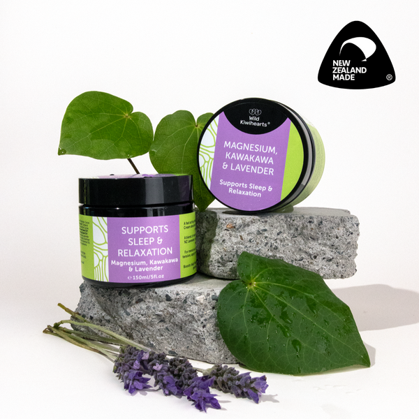 Two tubs of Wild Kiwihearts Magnesium, Kawakawa & Lavender cream with green leaves and lavender flowers on a white background.